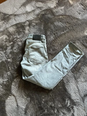 Ljusgråa tapered jeans - Säljer dessa stilrena gråa jeans ifrån märket Jack&Jones.                                        De är i modellen Tapered Mike I storlek  30/30 men skulle säga att de är något mindre.                                                                       De är nästintill aldrig använda 