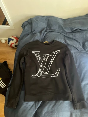 Svart sweatshirt med stor LV-logga - Snygg svart sweatshirt från lv riktigt fet skulle sig att den passar från 173-178 det beror lite på hur mkt ni väger