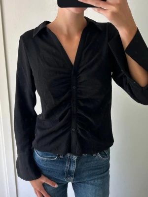Svart Blus - Sååååå fin blus i mycket bra skick! Rynkad detalj framtill   OBS! Har endast möjlighet att sälja under en kortare period