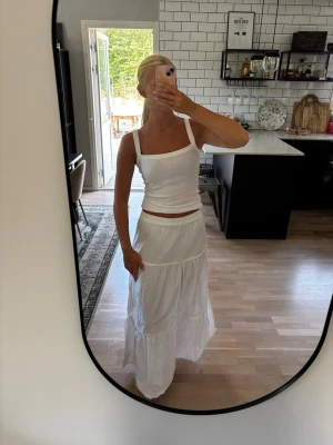 Vit långkjol med volangdetaljer - Säljer en vit långkjol med volangdetaljer och resår i midjan. Använd endast 2 gånger så produkten är i mycket bra skit. Jag är 163 cm lång. Publicerad på flera säljsidor 🌸