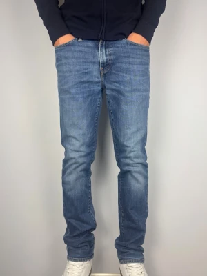 Levis 511 Jeans Vintage - Levis 511. Raka jeans. Färg: Blå med lätta fades | Modell: 511 | Storlek: W34 L34 | Vintage Premium Jeans. Passar perfekt på killen i bilden som är 189 cm. Lite slitna i grenen men inget som påverkas vid användning. Mått: A: 43 cm B: 108 cm C: 18 cm D: 27 cm Tveka inte att höra av dig minsta fråga eller fundering! Skickas snabbt!