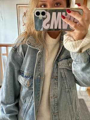 Oversized ljusblå jeansjacka mango  - Säljer en oversized ljusblå jeansjacka med klassisk krage och knappstängning framtill. Jackan har två bröstfickor med lock och knappar samt sömdetaljer som ger en cool vintagekänsla. Passar flera storlekar.