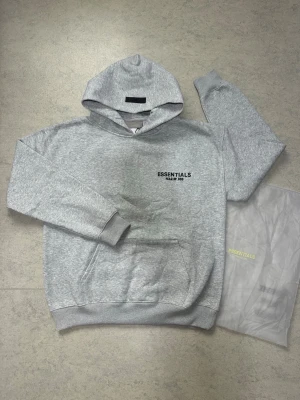  Essentials Fear of God  - Essentials grå hoodie  Grå Essentials hoodie i size S. Väldigt skön och bekväm med en stilren passform. Perfekt till vardags och streetwear, och den grå färgen passar enkelt med nästan allt. Fint skick och bra kvalitet.