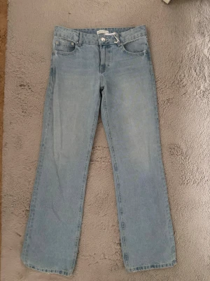 Ljusblå raka jeans - Säljer ett par ljusblå jeans med rak passform och klassisk femficksdesign. Perfekta för en avslappnad och trendig look.