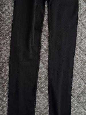 Svarta leggings med diskret mönster - Säljer ett par svarta leggings med diskret rutmönster. De har en smal passform och är stretchiga, vilket gör dem bekväma och lätta att röra sig i. Perfekta till en hoodie eller crop top.