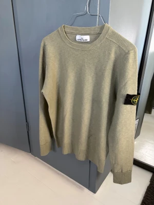 Olivgrön tröja från Stone Island - Snygg olivgrön tröja från Stone Island med klassisk rund hals och ribbade muddar. 