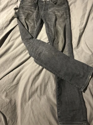 Jack and Jones jeans  - Säljer ett par gråa jeans från Jack and Jones som är i regular fit med storlek 32/34. De är nästan helt oanvändna och i mycket bra skick, inga skador eller slitage alls. Om ni har frågor är det bara att skriva.