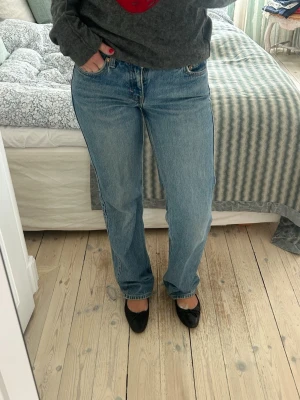 Blå raka jeans med låg midja - Säljer ett par klassiska blå jeans med rak passform och låg midja. Tecken på användning finns bl.a. nere vid skorna