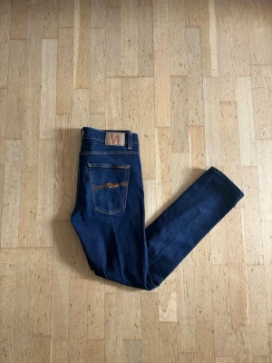 Nudie jeans - Säljer ett par mörkblå jeans från Nudie Jeans i modellen Lean Dean! Tvätten är dry 16 dips och är tillverkad av 99% bomull! Storleken är W34-L34 jag tycker den sitter mer som 32x32 har du frågor är de bara att fråga 