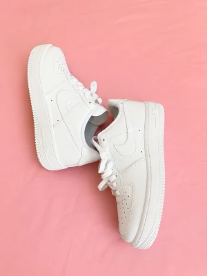 Vita klassiska sneakers - Stilrena vita sneakers i lågt snitt med perforerade detaljer på tån och sidorna. Skorna har en chunky sula och är tillverkade i slätt läder med matchande vita skosnören. Perfekta för en clean och modern look.