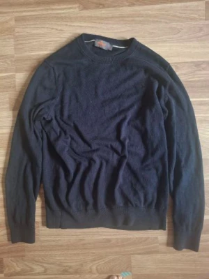 Mörkblå stickad tröja från Morris - Snygg mörkblå stickad tröja från Morris i 100% Pima Cotton. Tröjan har rund halsringning, långa ärmar och ribbade muddar vid ärmslut och nederkant. Perfekt för dig som gillar klassisk och stilren design.