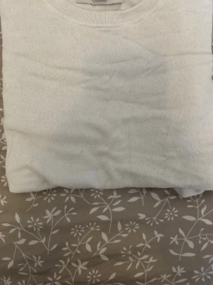 Vit stickad tröja från MISU - Vit stickad tröja från MISU med rund halsringning och ribbstickade muddar. Enkel och stilren design som passar perfekt till många olika outfits. Tillverkad i ett mjukt material som känns skönt mot huden.