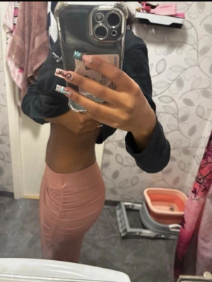 Cute kjol - Säljer en snygg rosa långkjol med rynkade detaljer längs sidorna. Kjolen har en tight passform och är gjord i ett mjukt, stretchigt material som sitter skönt på kroppen. Perfekt för dig som vill ha en stilren men ändå trendig look. Den är från Gina tricot men säljs ej längre 