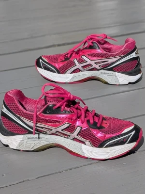 Rosa Asics löparsneakers Gel Gt-2160, stl 40 - Snygga rosa löparsneakers från Asics med vita och svarta detaljer. Skorna har mesh-ovandel för bra ventilation, vita och svarta sulor med rosa inslag samt klassisk Asics-logga på sidan. Perfekta för dig som gillar sportig stil och vill sticka ut.