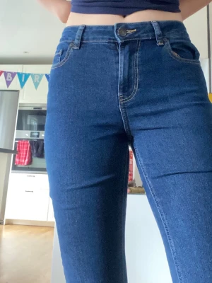 Blå bootcut jeans med hög midja - Säljer ett par klassiska blå bootcut jeans med ganska hög midja . Jeansen har utsvängda ben och är ifrån ADPT i storlek S