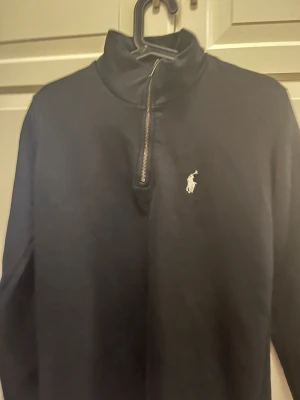 Svart halvzip tröja från Polo Ralph Lauren - Klassisk svart långärmad tröja från Polo Ralph Lauren med halvzip.