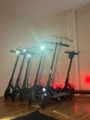 Svarta elsparkcyklar med LED-ljus - Flera svarta elsparkcyklar med LED-belysning fram och bak. De har robust ram i metall, stora hjul och klassisk design med styre och fotplatta. Perfekt för smidig transport i stan eller till skolan. Laddas enkelt via eluttag.