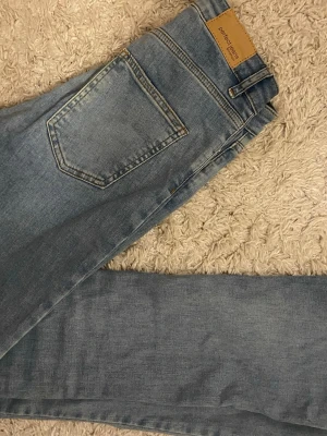 Ljusblå raka jeans från Perfect Jeans - Säljer ett par ljusblå jeans från Perfect Jeans med klassisk femficksdesign och bootcut. Jeansen har en snygg tvättad look och är tillverkade i ett mjukt denimtyg som är skönt att bära. Perfekta till en avslappnad stil. Säljer dom då dom är för små för mig🤍