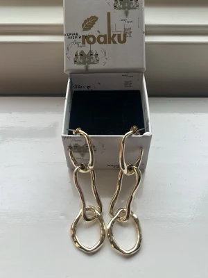 Coola ioaku örhängen💗 - Säljer mina helt nya ioaku örhängen i guld💗 nytt skick och jättecoola!! Passar jättebra nu till hösten🍁🍂