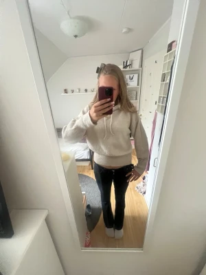 Beige hoodie med huva  - Mysig beige hoodie med huva. Hoodien har en avslappnad passform, ribbade muddar vid ärmslut och midja samt en mjuk, lite fluffig yta. Perfekt för chill dagar och enkel att matcha med jeans eller leggings.