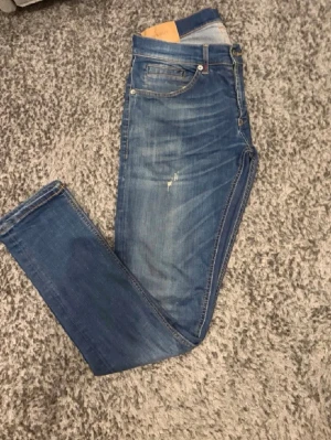 Dondup geroge jeans - Säljer ett par blå slim fit jeans med snygga slitningar och tvättade detaljer. Nu pros 2500 mitt pris 449