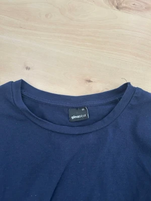 Marinblå T-shirt med resår  - En snygg nästan helt oanvänd marinblå t shirt från Gina tricot med resår i nederkant perfekt look för dig som gillar Stockholms stilren och vill ha en tajt med skön T-shirt som passar till allt 💗