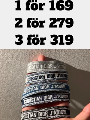 Dior armband - Säljer snygga Christian Dior J'adior armband i olika färger som grå, blå och svart. Armbanden är breda och har tydlig broderad text. Perfekt accessoar för att lyfta din outfit och visa din stil.