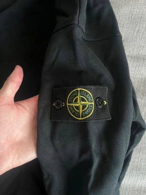 Stone Island sweatshirt svart - Säljer denna galet snygga stone Island sweatshirt i storlek M/L. Säljer då den tyvärr inte kommer till användning något mer. Passar till alla tillfällen. Kan gå ner i pris i en snabb och smidig affär! Köparen står för frakten😁