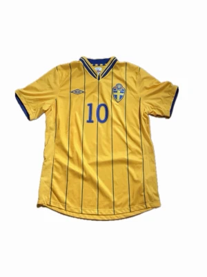(Äkta) Sverige Hemma 2012 Ibrahimović #10 - Skick: 10/10                                                         Sveriges hemmatröja från 2012 som dels användes under EM 2012 i Ukraina och Polen.Men för många är denna tröja framför allt förknippad med den historiska premiärmatchen på Friends Arena. Den 14 november 2012 skrev Zlatan historia genom att göra 4 mål och det fjärde genom den legendariska bicycletan från 30 meter.                                        Bara att skriva vid frågor!🦁🇸🇪