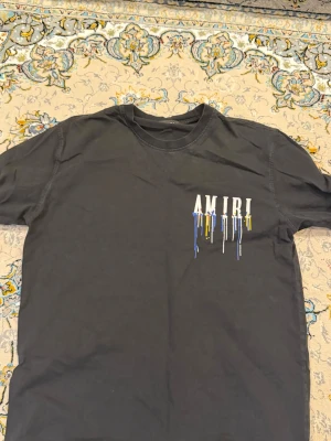 Svart AMIRI t-shirt med färgstänk - Kolla 2 sista bilder för de enda defekterna på t shirten. Storlek L men passar också M