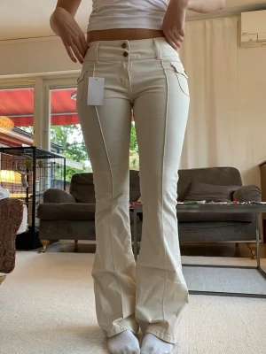 Bootcut byxor  - Ett par vita/beige lågmidjade bootcut byxor. De har lappen kvar och är aldrig använda. Köpta för 440 kr från Brandy Melville. 