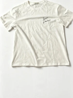 Vit Saint Laurent t-shirt - Vit t-shirt från Saint Laurent med svart logotyptryck både fram och bak. Bara att höra av sig om du är intresserad. Mvh.
