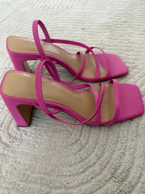 Rosa klackskor  - Snygga rosa klackskor från H&M med fyrkantig tå och blockklack. Oanvända men tagit bort prislappen. 