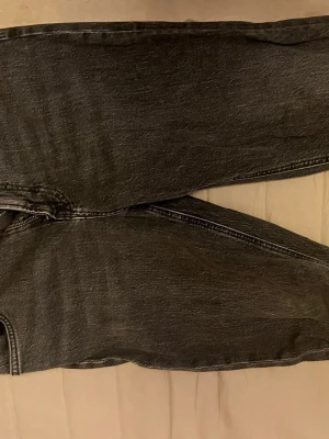 Grå tvättade jeans från Lee - Säljer ett par grå tvättade jeans från Lee med klassisk femficksmodell och raka ben. Jeansen har en vintagekänsla och är tillverkade i slitstarkt denimtyg. Endast använt ett fåtal gånger.