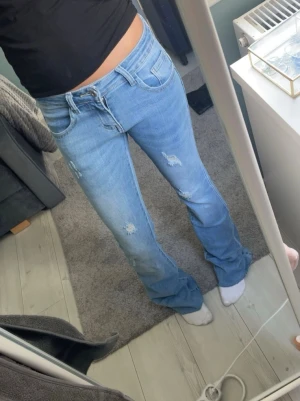 Ljusblå bootcut jeans med slitningar - Från Ronja co,dom är i rålängd så dom är till för att lägga upp,använda ett fåtal gånger och är i mycket bra skick.stolek xs/34