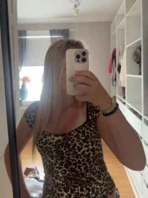 Leopardmönstrad topp med v-ringning - Leopard mönstrad kortärmad topp med urringning från Nelly. Stretchigt material samt spetsdrtalj längst urringningen.💕