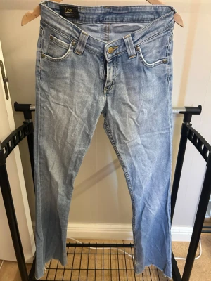 Ljusblå bootcut jeans från Lee - Säljer ett par ljusblå bootcut jeans från Lee. Använda och slitna vid fötterna, se bilder 