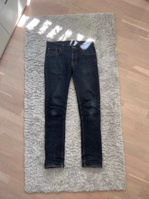 Mörkblå Nudie Jeans - Säljer dessa feta grim Tims med snygga fades. Storlek W33 L34. Tveka inte att skriva vid intresse eller funderingar kring mått etc.