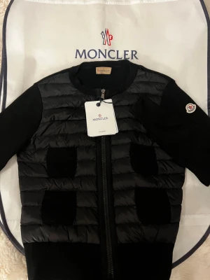 Svart cardiganjacka från Moncler - Säljer min äkta Moncler jacka pågrund av att jag samlar till en vinter modell. Jackan har ett hål i armhålan jag inte märkt av förens jag tog bilderna och kommer därför säljas för en billigare peng 🤍 jackan passar dig om du bär storlek S/M
