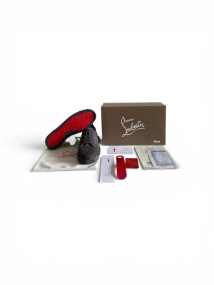 Grå sneakers från Christian Louboutin - Snygga grå sneakers från Christian Louboutin i mocka med klassisk röd sula och rund tå. Skorna har snörning och en stilren design som passar perfekt till streetwear. Levereras med originalkartong och tillbehör.