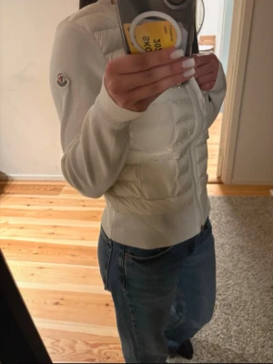Moncler cardigan dam - Säljer min jättefina Moncler cardigan i färgen vit, storlek S. Superbekväm och stilren, med vadderad framsida och stickade ärmar – så fin på! Passar till allt och perfekt både till vardag och när man vill vara lite extra snygg. 