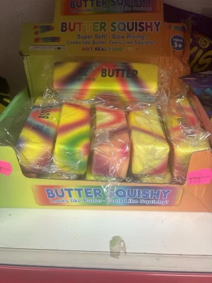Butter Squishy regnbågsfärgad leksak - Butter Squishy är en mjuk och färgglad squish-leksak som ser ut som ett smörpaket i regnbågsfärger. Den är tillverkad av ett mjukt, skumliknande material och passar perfekt för att klämma på när man vill stressa ner eller bara ha kul.