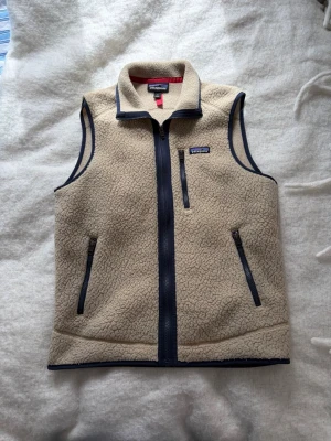 Beige fleeceväst från Patagonia - Säljer min väst från patagonia, västen är i mycket bra skick då jag knappt har använt den, knsk max 5 gngr. Skriv vid fler frågor. 