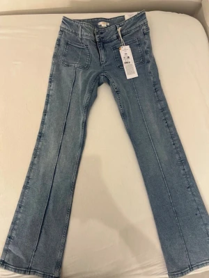 Gina Tricot flared jeans 164 (oanvända) - Mörkblå jeans från Gina Tricot i storlek 164. Oanvända med lapp kvar. Har fickor framtill och stretch i tyget, se bilder. Fint skick!