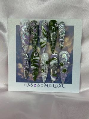 V1RU5 (S);ExtrLongStiletto - Unika handgjorda press-on naglar i en extra lång stilettoform med mix av mörkgrönt, silver, vitt och lila. Naglarna har 3D-detaljer, swirlmönster och metallic-effekt. Perfekt för dig som vill sticka ut med kreativa och konstnärliga naglar. S: 15 mm, 11,5 mm, 12 mm, 11 mm, 9 mm 