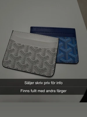 Mönstrade kortfodral i vitt och blått - Två stilrena kortfodral i vitt och blått med grafiskt mönster. De har plats för flera kort och är tillverkade i ett slätt material som liknar konstläder. Perfekt för dig som vill ha ett smidigt och snyggt sätt att bära dina kort.
