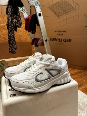Vita sneakers med grå detaljer - helt nya b30s i storlek 41. finns box och kvitto om det behövs. Fraktas ut samma dag. Pris kan diskuteras