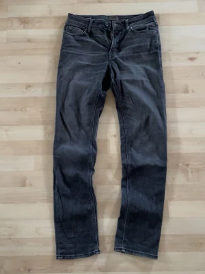 Mörkgrå Jack and Jones jeans  - Snygga mörkgrå jeans från Jack and Jones i modellen regular Clark, strl 31/34