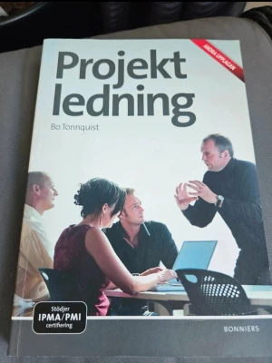 Projektledning av Bo Tonnquist - Kursbok i projektledning av Bo Tonnquist, utgiven av Bonnier Utbildning. Omslaget är grått med en bild på fyra personer i möte och texten 'Stöder IPMA/PMI certifiering'. Perfekt för dig som pluggar eller jobbar med projektledning.