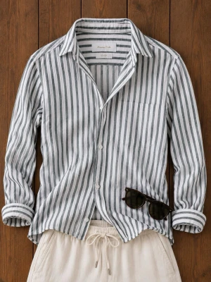 Randig linneskjorta från Massimo Dutti - Säljer en snygg vit skjorta med mörkgrå vertikala ränder från Massimo Dutti. Skjortan är i 100% linne, har lång ärm, klassisk krage och knäppning framtill. Perfekt för en avslappnad och stilren look.